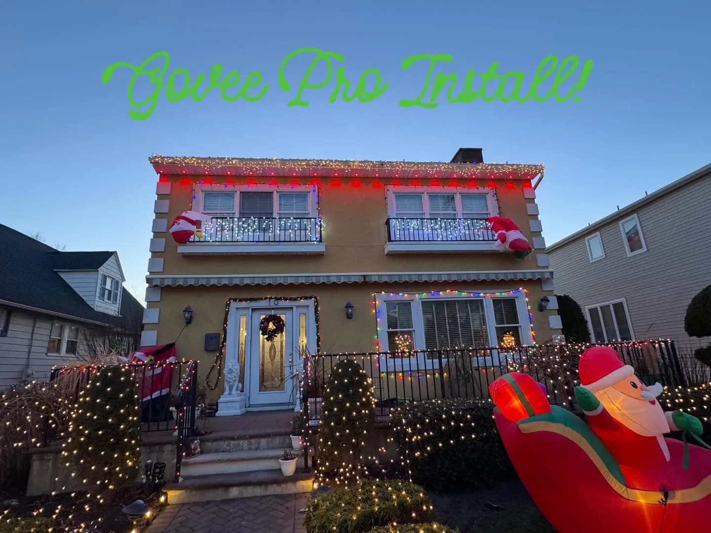 Two-story home with red permanent accent lighting over holiday string lights