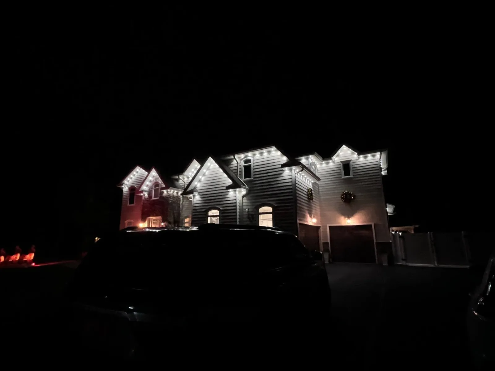 Multi-gable home outlined in soft white permanent lighting